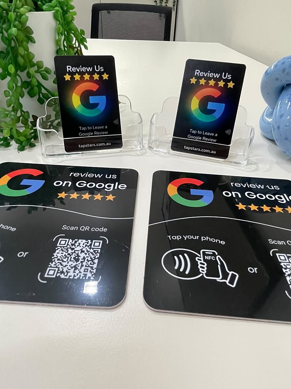 Close-up of Tap Star review cards in card holders behind two black review plaques