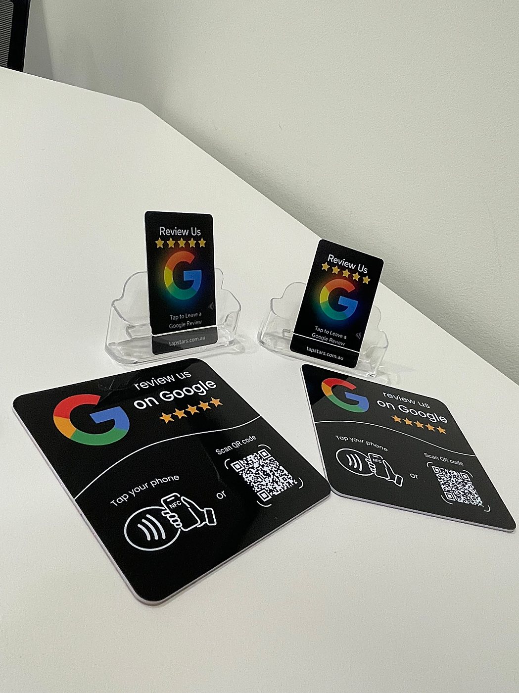 Tap Star review cards in clear holders next to two black review plaques on a counter